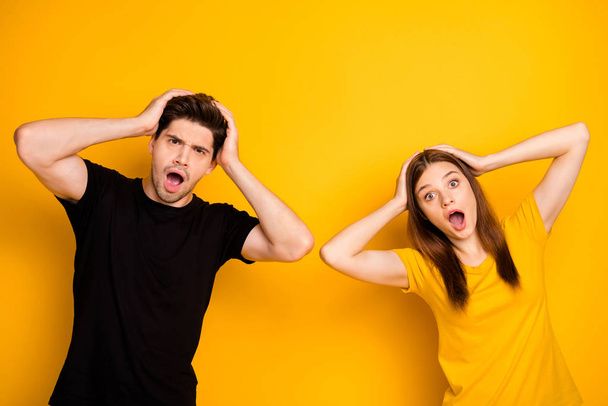Photo of disappointed shocked in negative couple of two people expressing bad emotions failed wearing black t-shirt isolated vivid color background - Foto, immagini