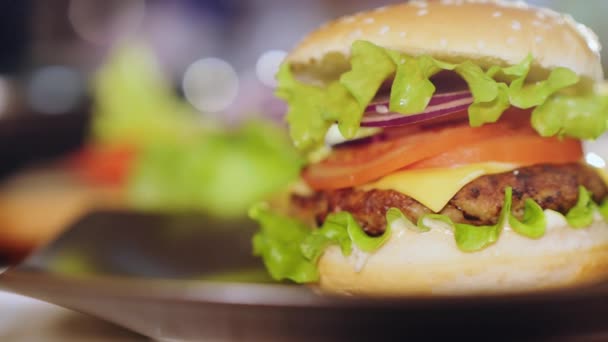 Šťavnatý hamburger na talíři, zblízka - Záběry, video