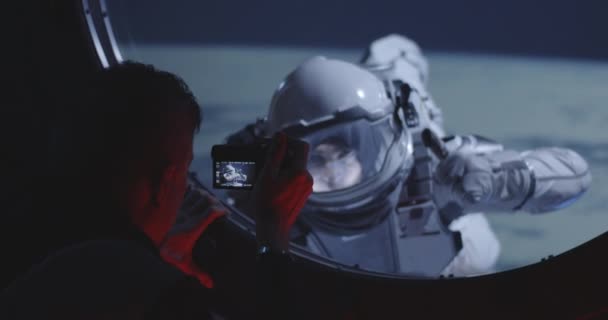 Astronauta filmando companheiro de equipe de caminhada espacial
 - Filmagem, Vídeo