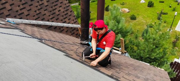 Werknemer doet de installatie van het dak van het huis. Installatie - Foto, afbeelding