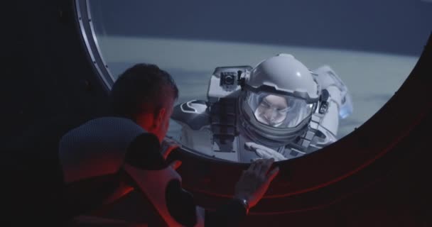 Astronauta hablando con compañero de equipo de caminata espacial
 - Imágenes, Vídeo