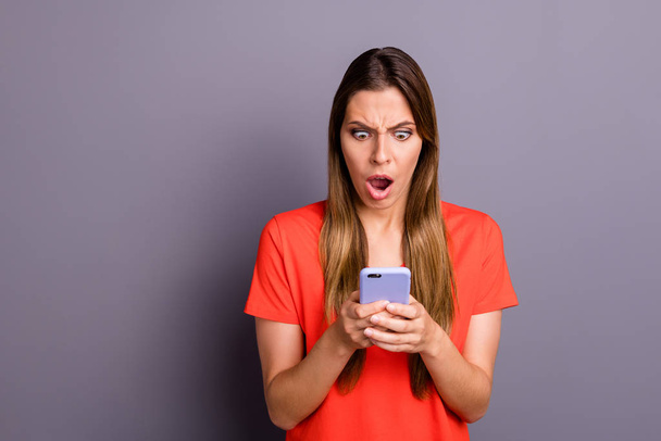 Omg unbelievable. Impressed frustrated girl use her smartphone read social network news got notification scream wear beautiful clothes isolated over grey color background - Photo, image