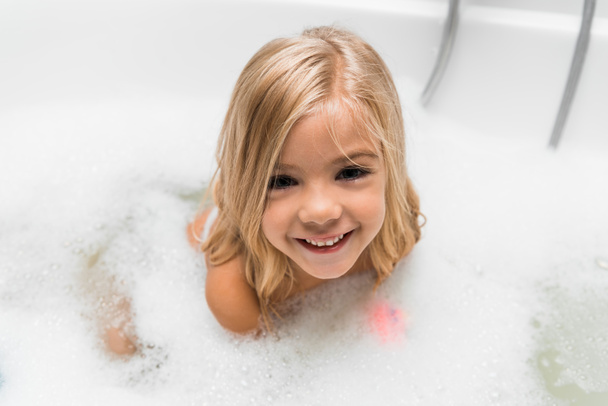 overhead view of happy naked child taking bath - Zdjęcie, obraz