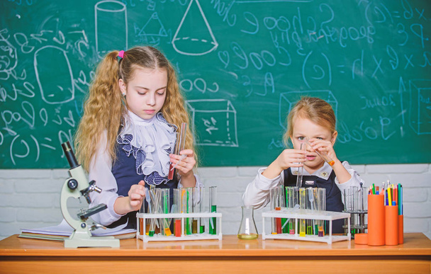 Improving their study skills. Study group in chemistry laboratory. Little school children holding test tubes during study session. Small schoolgirls performing study experiment in chemistry - Valokuva, kuva