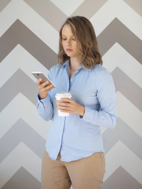 Businesswoman with coffee cup using mobile phone  - Foto, immagini
