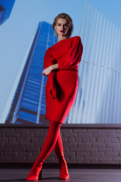 femme attrayante et élégante en robe rouge sur fond de ville
  - Photo, image
