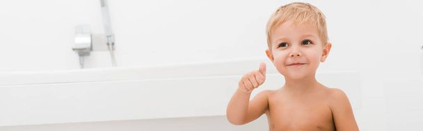 Panoramaaufnahme eines glücklichen Kleinkindes, das im Badezimmer gestikuliert  - Foto, Bild