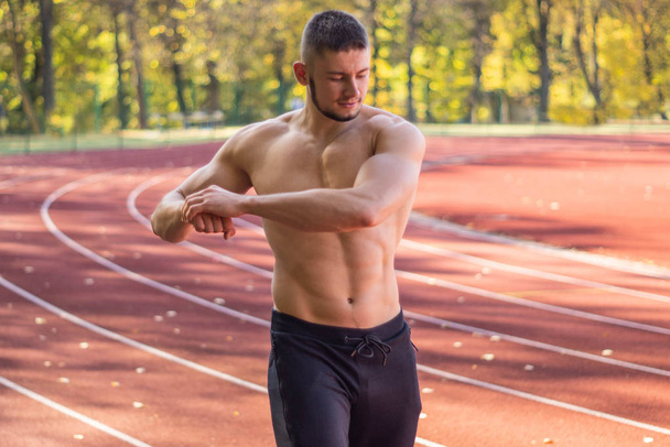 Mužský model se svalovou kondicí a štíhlým tělem na stadionu.  - Fotografie, Obrázek