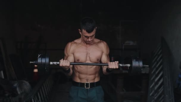 Close view of a strong sportsman lifting a barbell in the gym - Felvétel, videó