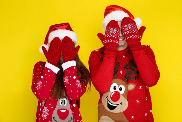 Beautiful man and woman in christmas sweaters and santa hats on  - Foto, Imagem