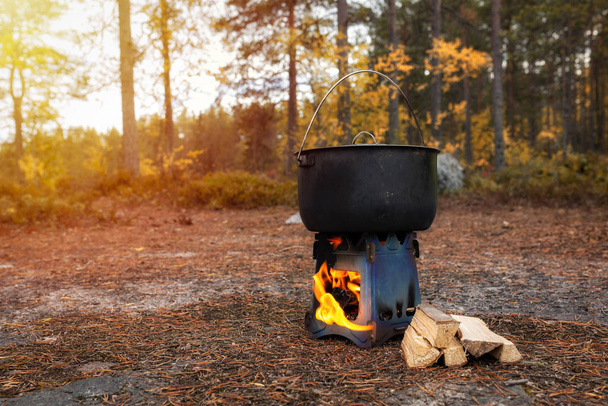 Kochen von Essen auf einem Herd. Mini-Herd mit Lagerfeuer im herbstlichen Wald. - Foto, Bild