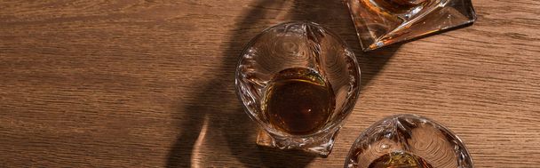 Top view of brandy in glasses and decanter on wooden table, panoramic shot - Fotó, kép