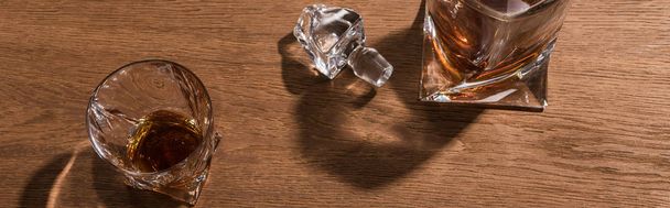 Horní pohled na brandy ve skle a karafě na dřevěném stole, panoramatický záběr - Fotografie, Obrázek