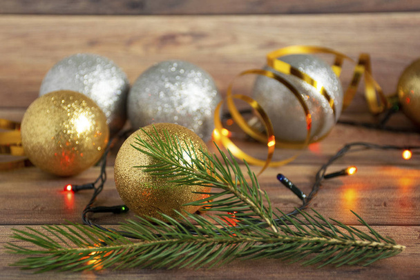 Gold and silver Christmas balls and multi-colored garland on a wooden Christmas background. Copyspace. - Photo, Image