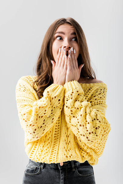 shocked girl covering mouth with hands and looking away isolated on grey - Foto, afbeelding