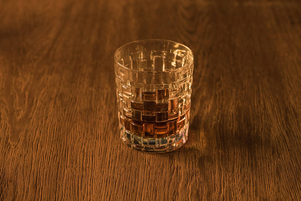 Textured glass of brandy on wooden table - Foto, imagen