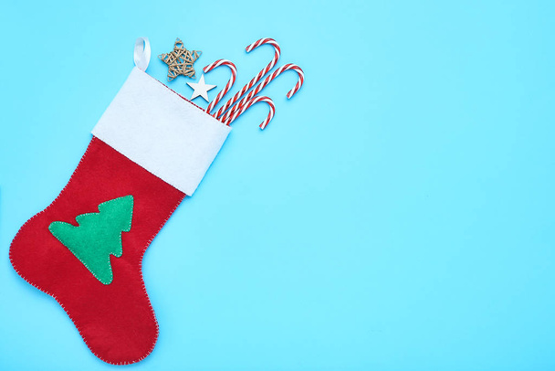 Red christmas stocking with stars and candy canes on blue background - Foto, Imagem