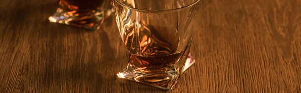 Dos copas de brandy sobre mesa de madera, plano panorámico
 - Foto, Imagen