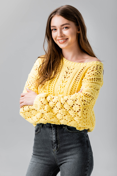 attractive girl in yellow sweater smiling at camera isolated on grey - Foto, imagen