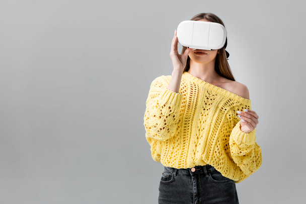 young woman in yellow sweater using vr headset isolated on grey - Fotografie, Obrázek