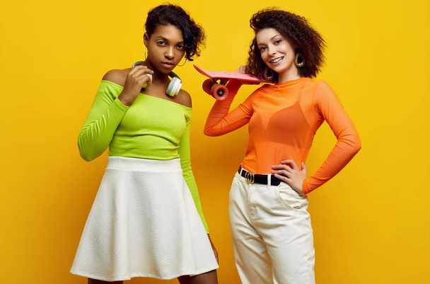 Duas jovens meninas hipster bonitas na moda roupas coloridas de verão
 - Foto, Imagem