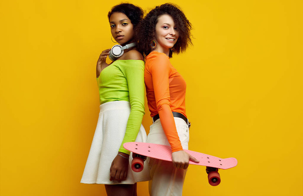 Δύο νεαρά όμορφα hipster κορίτσια σε μοντέρνα πολύχρωμα καλοκαιρινά ρούχα - Φωτογραφία, εικόνα