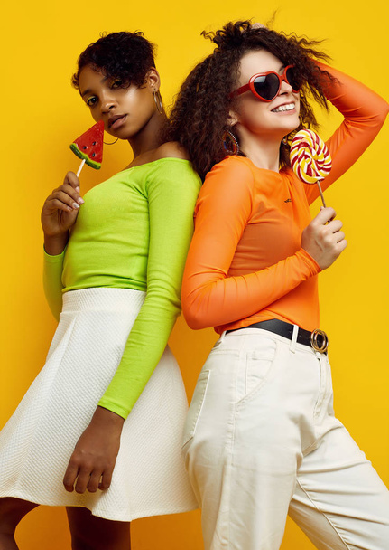Due giovani belle ragazze hipster in abiti estivi colorati con lecca-lecca
 - Foto, immagini