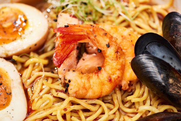 close up view of spicy seafood ramen with shrimps, eggs and mussels - Valokuva, kuva