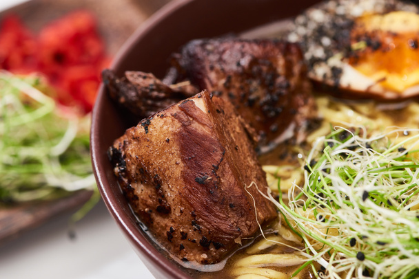 close up view of spicy ramen with beef and microgreen in bowl - Zdjęcie, obraz