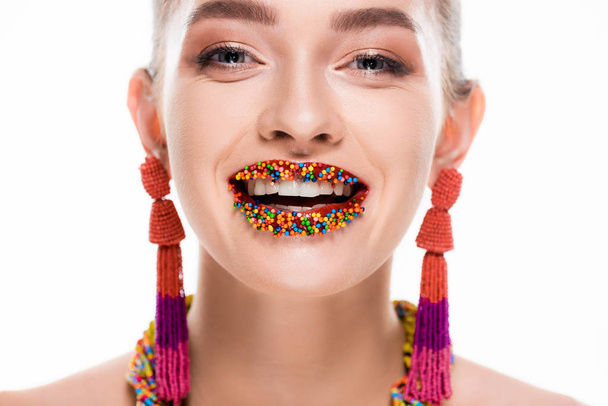 beautiful girl in beaded earrings, with beads on lips, smiling at camera isolated on white - Фото, изображение