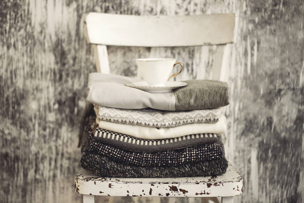 Pile of knitted warm grey and white blankets, scarves and woolen - Photo, Image