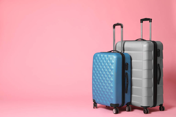 Stylish grey and blue suitcases on pink background. Space for te - Photo, image