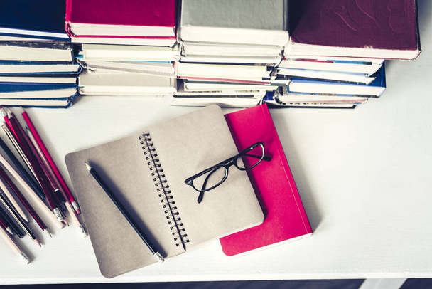 Notebook, pencils, glasses and stack of books, school background - Valokuva, kuva