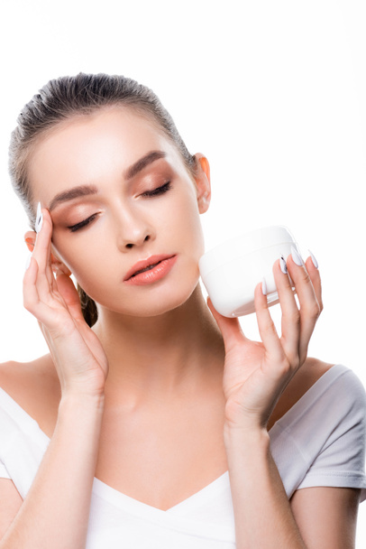beautiful girl applying face cream with closed eyes isolated on white - Foto, Imagem