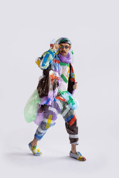 Man addicted of sales and clothes, wearing plastic, recycling concept - 写真・画像