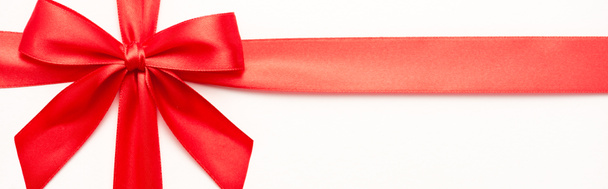 panoramic shot of decorative red ribbon with bow isolated on white  - Foto, Bild