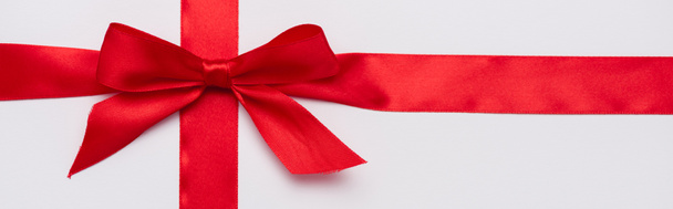 panoramic shot of satin ribbon with red decorative bow isolated on white  - Φωτογραφία, εικόνα