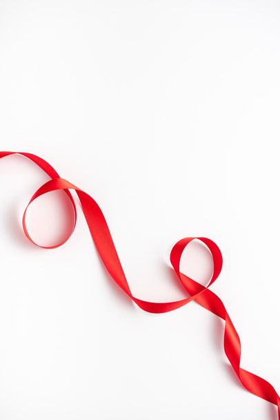 top view of red and curled ribbon on white  - Foto, Imagen