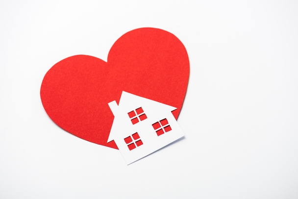 Красное сердце рядом с бумажным домом изолированы на белом
  - Фото, изображение