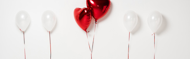 πανοραμική λήψη κόκκινων μπαλονιών σε σχήμα καρδιάς σε λευκό  - Φωτογραφία, εικόνα