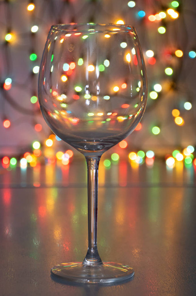 kieliszek do wina z winem musującym na tle girlandy - Zdjęcie, obraz