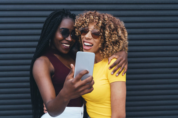 Lasst uns ein Selfie machen: Zwei liebevolle junge Frauen umarmen sich - Foto, Bild