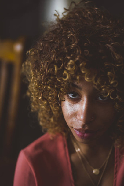 Selective focus of a woman smiling looking up with a beautiful curly hair. - Foto, Bild