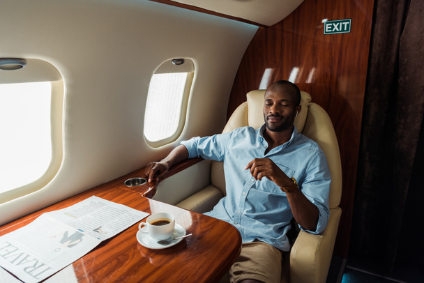bonito afro-americano homem ouvindo música em avião privado
  - Foto, Imagem
