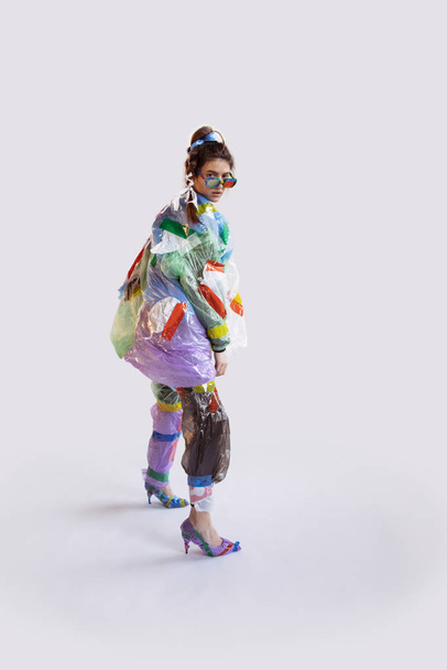 Woman addicted of sales and clothes, wearing plastic, recycling concept - Photo, Image