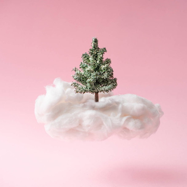 composition of Christmas tree on cloud against pink background. Happy holidays, new year minimal concept. - Fotó, kép