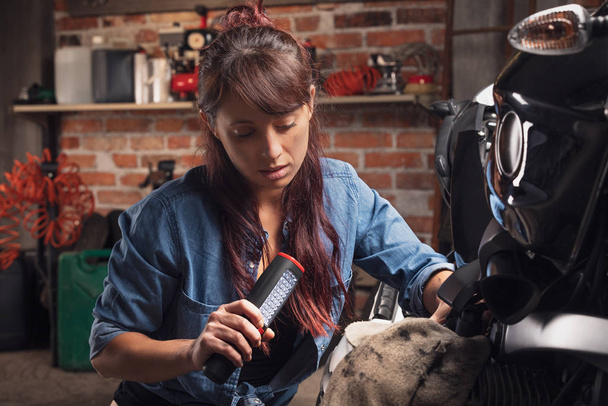 junge Frau arbeitet an einem Oldtimer-Motorrad - Foto, Bild