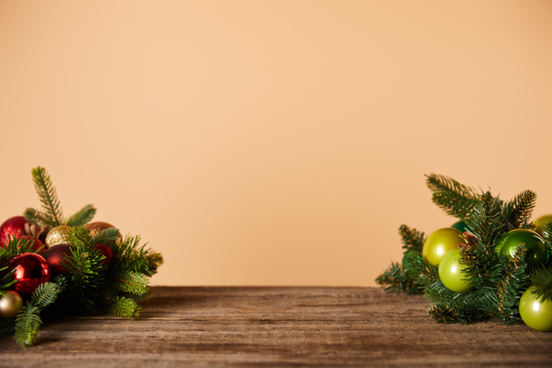 ramas de abeto con bolas de Navidad en la mesa de madera en beige
 - Foto, Imagen