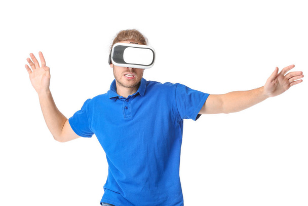 Young man with VR glasses on white background - Φωτογραφία, εικόνα