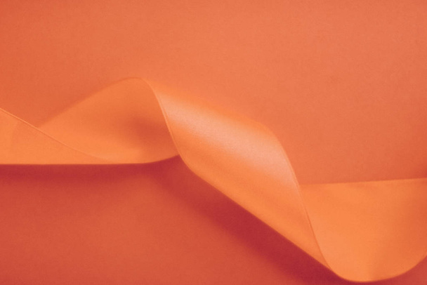Ruban de soie bouclé abstrait sur fond orange, luxe exclusif
 - Photo, image